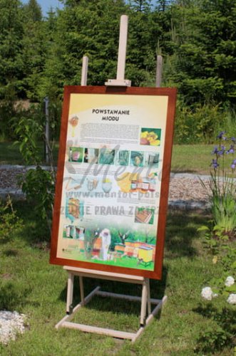 Tablica pszczelarska w ramce drewnianej, prezentowana w terenie na sztaludze drewnianej, dużej.